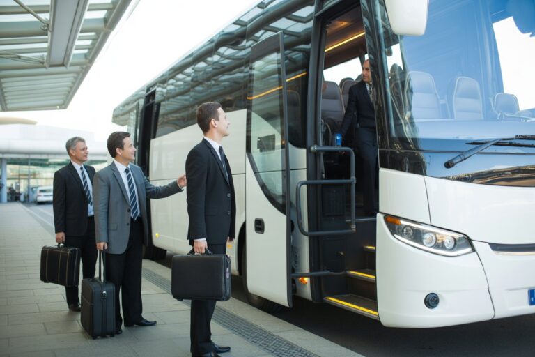 kierowca autokaru zapraszający biznesmanów do pojazdu