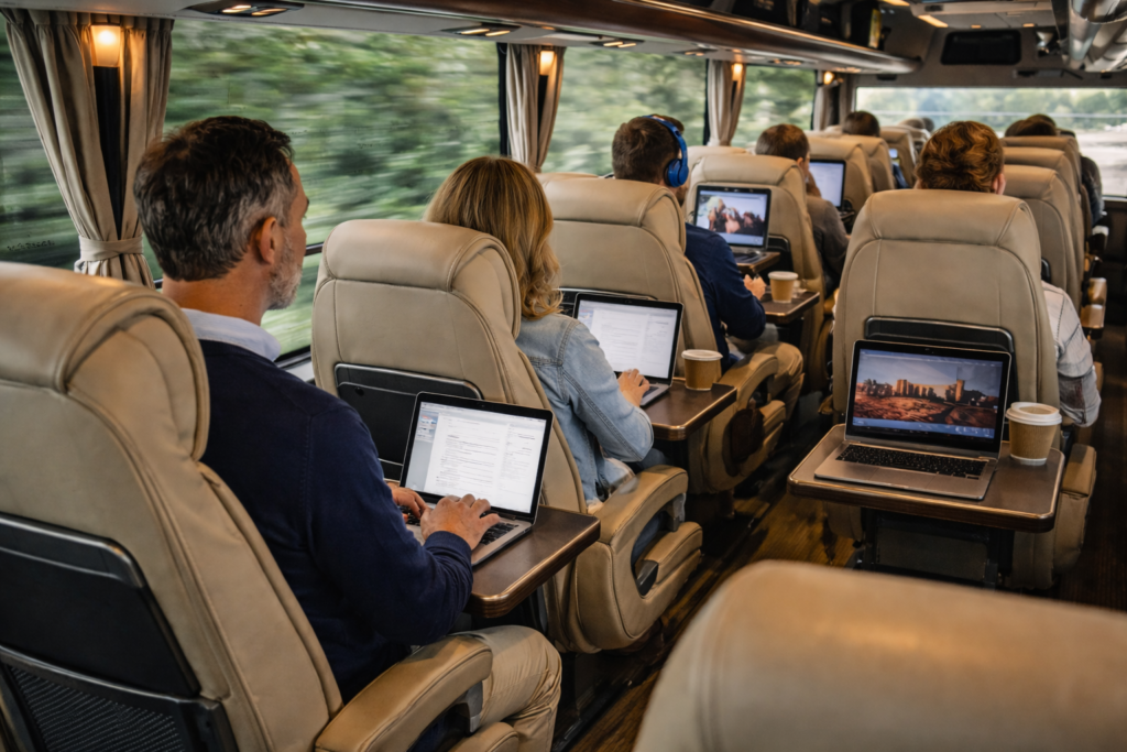 wnętrze luksusowego autokaru - ludzie pracujący na laptopach